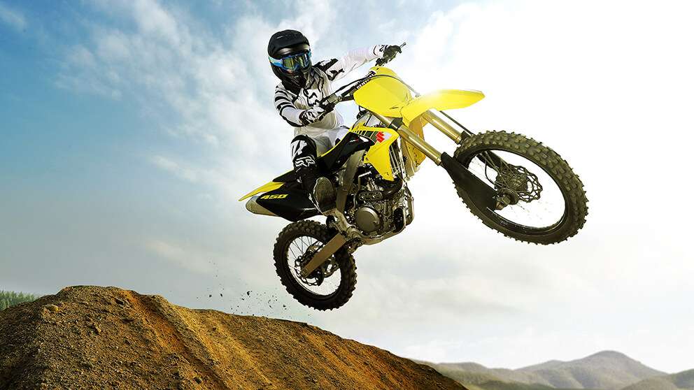 Suzuki dirt bike jumping over new powersports inventory at Statesboro Powersports
